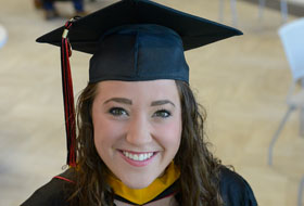 Female graduate smiling in her cap and gown